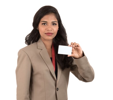 Smiling business woman holding a blank business card or ID card over white background photo