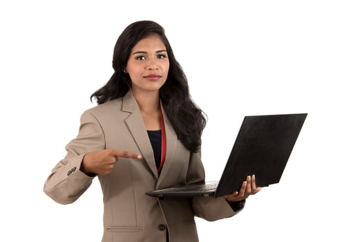 Happy excited business woman holding laptop and pointing on it isolated on a white background photo