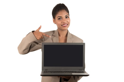 Happy excited business woman holding laptop and pointing on it isolated on a white background photo