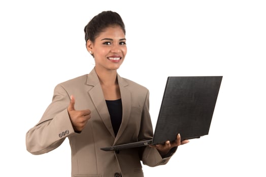 Happy excited business woman holding laptop and showing thumbs up isolated on a white background photo