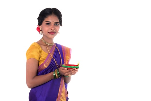 Portrait of a woman holding diya, Diwali or deepavali photo with female hands holding oil lamp during festival of light on white background