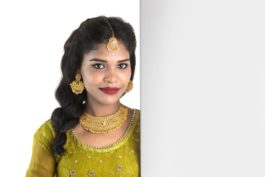 Traditional Girl holding and showing blank white sign board photo