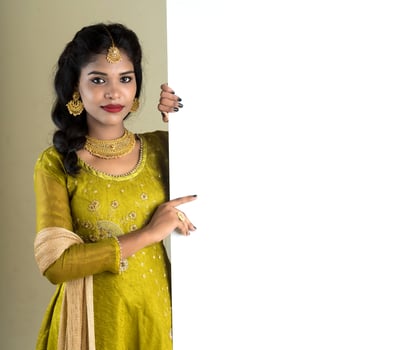 Traditional Girl holding and showing blank white sign board photo
