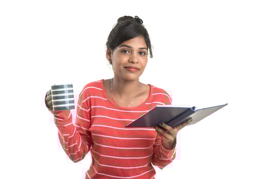 Beautiful young girl with book and cup of coffee posing on a white background. photo