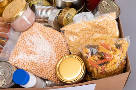 Donation Box of Free Food. Carton Box with Canned Food, Cereals and Grocery. Meal Reserves. Emergency Food Storage in Case of Crisis. Free Social Help, Blessings and Care. Strategic Food Supplies photo