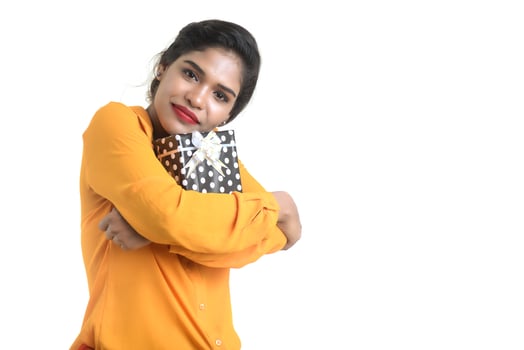 Portrait of young happy smiling Indian Girl holding gift boxes on a white background. photo