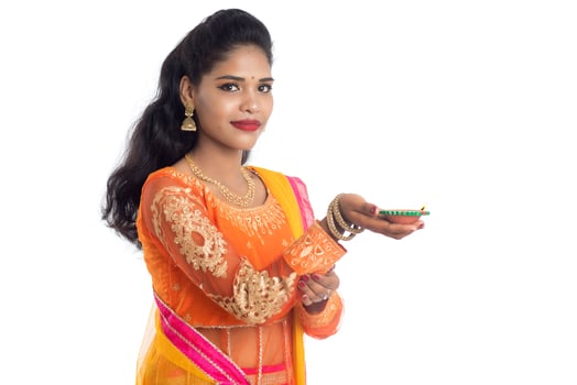 Portrait of a Indian Traditional Girl holding Diya, Girl Celebrating Diwali or Deepavali with holding oil lamp during festival of light on white background photo