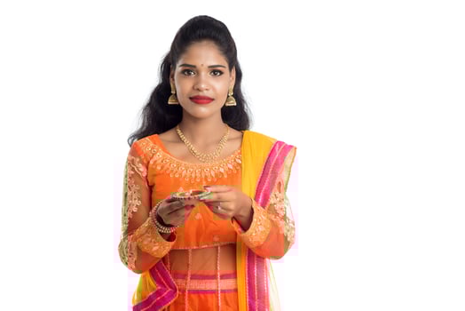Portrait of a Indian Traditional Girl holding Diya, Girl Celebrating Diwali or Deepavali with holding oil lamp during festival of light on white background photo