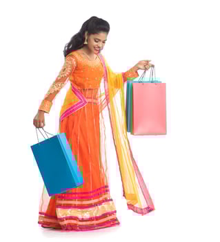Beautiful Indian young girl holding shopping bags while wearing traditional ethnic wear. Isolated on a white background photo
