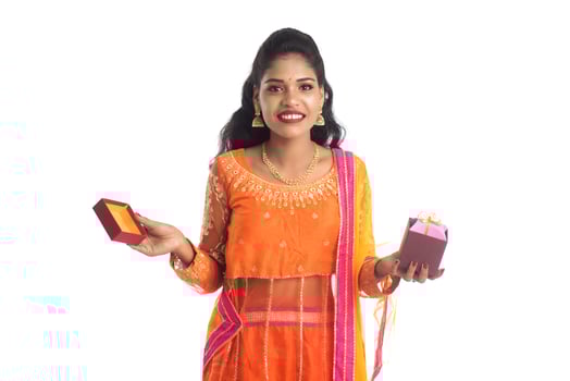 Portrait of young happy smiling Indian Girl holding gift boxes on a white background. photo