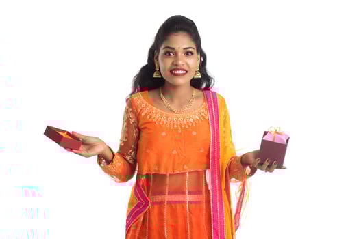 Portrait of young happy smiling Indian Girl holding gift boxes on a white background. photo