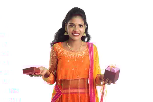 Portrait of young happy smiling Indian Girl holding gift boxes on a white background. photo