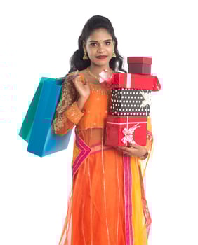 Beautiful woman carrying many shopping bags and gift Box on a white background. photo