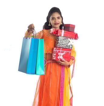 Beautiful woman carrying many shopping bags and gift Box on a white background. photo