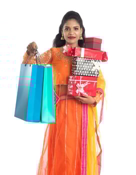 Beautiful woman carrying many shopping bags and gift Box on a white background. photo