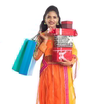 Beautiful woman carrying many shopping bags and gift Box on a white background. photo