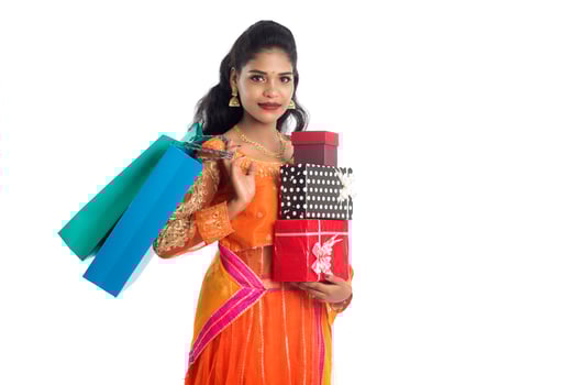 Beautiful woman carrying many shopping bags and gift Box on a white background. photo