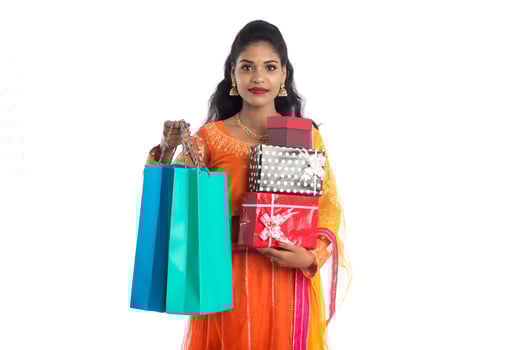 Beautiful woman carrying many shopping bags and gift Box on a white background. photo