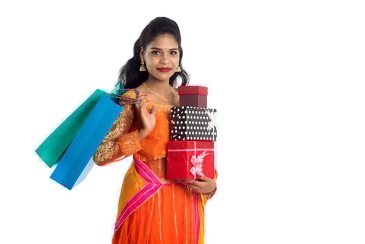 Beautiful woman carrying many shopping bags and gift Box on a white background. photo
