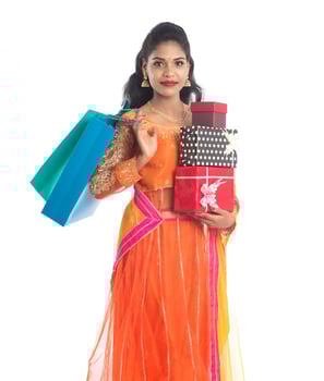Beautiful woman carrying many shopping bags and gift Box on a white background. photo