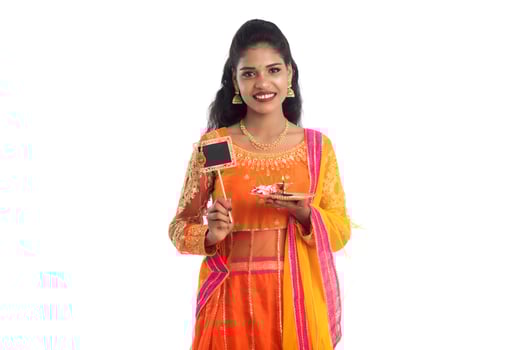 Beautiful Indian girl showing Rakhi on occasion of Raksha Bandhan with pooja thali and black board. Sister tie Rakhi as a symbol of intense love for her brother. photo