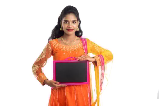 Beautiful young woman holding and posing with a blank chalkboard slate on a white background photo