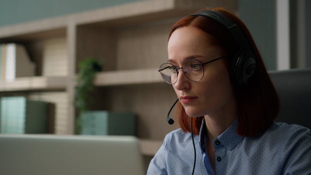 Caucasian business woman in headset communicate with clients solve problem female girl office worker conference call with laptop computer. Serious businesswoman speaking talk webcam distant chat photo