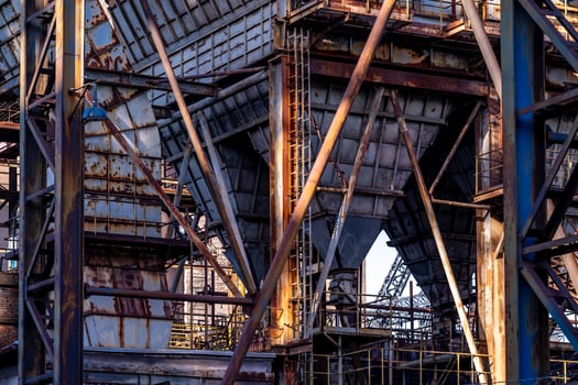 Rusty industrial building with crumbling facade showing decaying metal structure photo