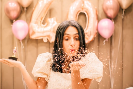 Close up pretty mature natural looking happy slim caucasian woman celebrate birthday party blow blister blow cupcake candle photo