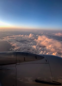 Golden sunset sky with fluffy ornamental clouds, panoramic view from an airplane photo