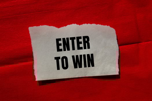 Enter to win message written on ripped torn paper piece on red background. Conceptual enter to win symbol. Copy space. photo