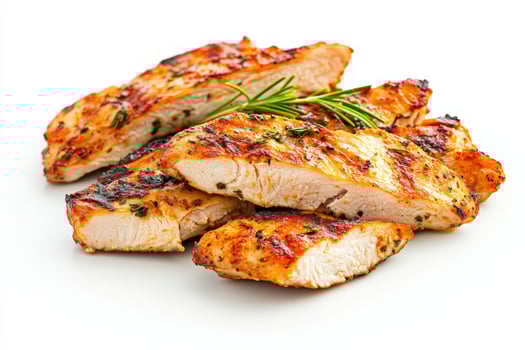 Juicy grilled chicken slices are artistically arranged on a plain background, garnished with fresh herbs. This dish offers a visually appealing option for healthy dining and meal preparation. photo