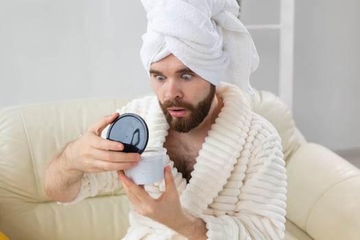 Portrait of man applying effective cream on his facial skin. Spa at home, body and skin care for male concept. photo