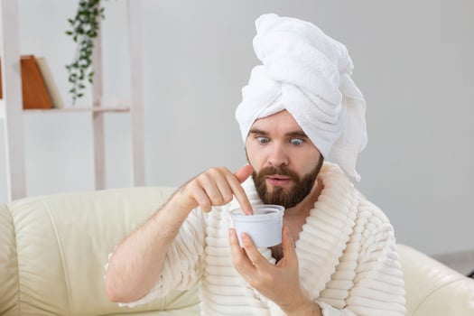 Portrait of man applying effective cream on his facial skin. Spa at home, body and skin care for male concept. photo