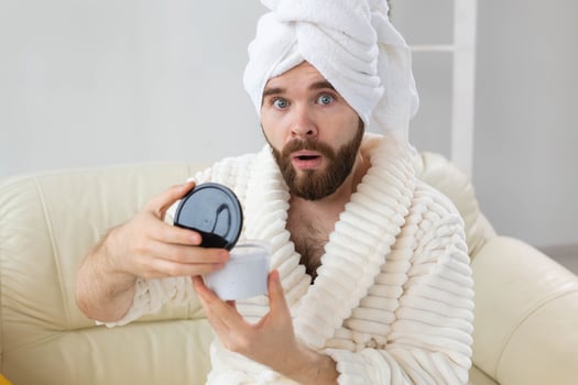 Portrait of man applying effective cream on his facial skin. Spa at home, body and skin care for male concept. photo