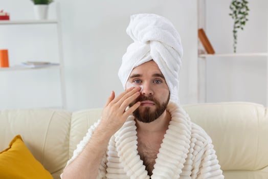 Bearded man applying eye patches on his face. Wrinkles and face home care for men. photo