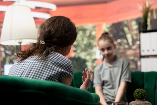 Adolescent girl talking about her struggles with mental health in a therapy session. Psychotherapist helps her navigate depression and the emotional challenges of hormonal shifts. photo