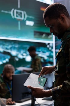 Government intelligence officers in an operation room managing surveillance activity, gathering intelligence to help the troops. Analyzing real time data for national interests protection. photo