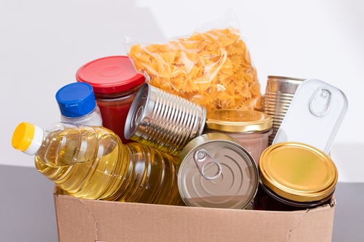 Donation Box of Free Food. Carton Box with Canned Food, Cereals and Grocery. Meal Reserves. Emergency Food Storage in Case of Crisis. Free Social Help, Blessings and Care. Strategic Food Supplies photo