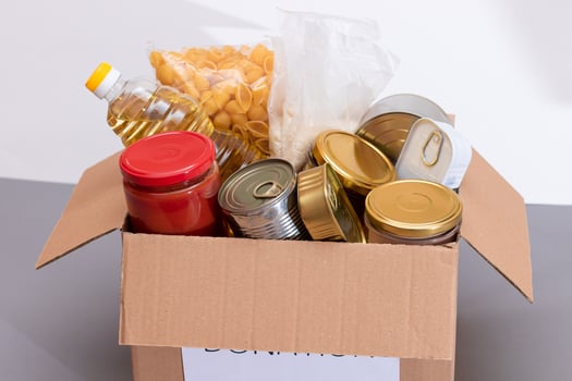 Donation Box of Free Food. Carton Box with Canned Food, Cereals and Grocery. Meal Reserves. Emergency Food Storage in Case of Crisis. Free Social Help, Blessings and Care. Strategic Food Supplies photo