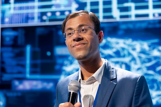 Speaker talking at tech conference, exploring latest AI technology trends, case studies, and use cases. IT expert presenting how artificial intelligence will shape the future during event photo