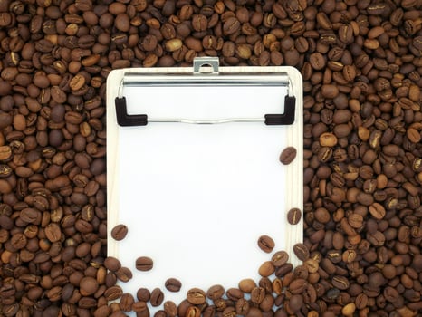 Board on coffee beans texture background. Paper for notes. Top view. photo