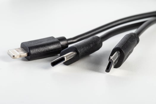 Universal black 3 in 1 charging cable with different charging connectors on a white background, close-up. Type-c, usb-c, micro-usb photo