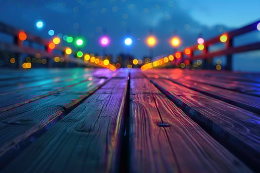 Defocused city lights create a colorful bokeh effect on a wooden boardwalk at night. photo