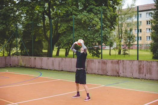 Volleyball player practicing setting the ball on a hard court, focusing on control and precision during an outdoor training session. A calm, focused moment in the game photo