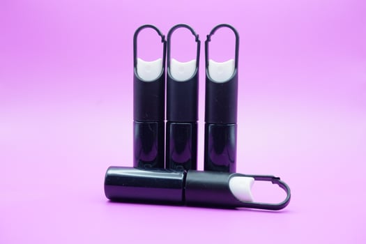 mini sprayer bottles isolated on purple background. four sprayer bottles with hangers photo