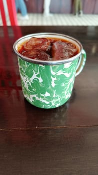 cup of ice tea with green ornament glass on the table photo
