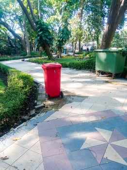 a trash can placed in a city park. concept of keeping the environment clean photo