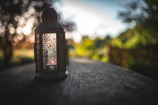 Oil, candle lantern on a wooden table on a camping site. photo
