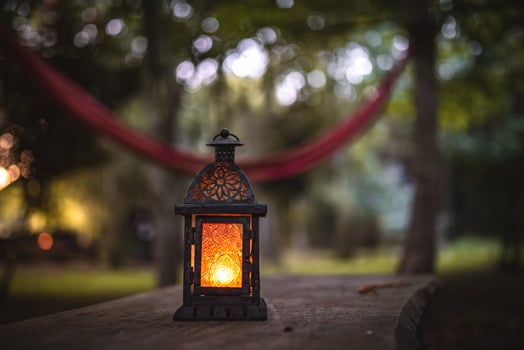 Oil, candle lantern on a wooden table on a camping site. photo